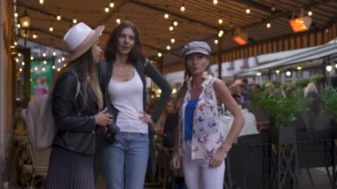 Sohbet ve ışık sırt çantaları riga şehir keşfetmek ile üç seyahat kız arkadaşlar - Havaalanından transfer sonra seyahat turizm konsepti - şapka ve kot giyen