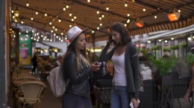 DSLr kamera fotoğrafları kontrol iki seyahat kız arkadaş ve arkadaşları Riga şehirde onları kucaklıyor - Havaalanından transfer sonra Seyahat turizm konsepti - Şapka ve kot giyiyor