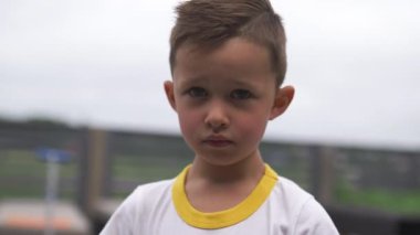 Yakın yüz portre: Sevimli çocuk görünümlü ve kamera ayakta gülümseyen - alan sığ derinliği