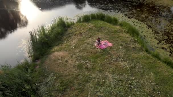 Aerial: młoda matka z córką dziewczynki na piknik w parku-wartości rodzinne ciepły kolor lato scena Drone Top strzał z góry — Wideo stockowe