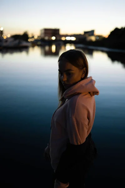 Портрет блондинки, стоящей у реки ночью — стоковое фото