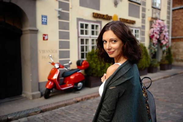 Šťastná žena portrét sexy stěhování na červeném motocyklové pozadí v nádherné staré město Riga — Stock fotografie