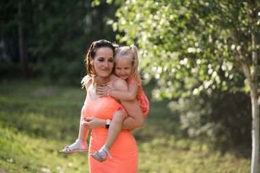 Mutlu anne onun küçük bebek kız kızı ile oynarken ve eğlenmek - Genç kafkas beyaz anne yaz parlak canlı renk elbise giyiyor - Happinness aile konsepti