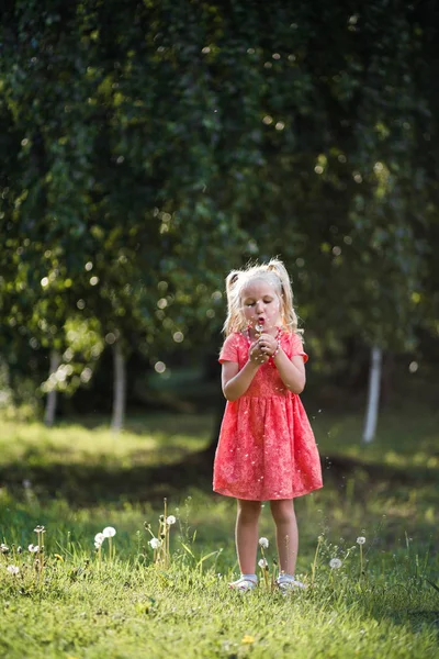 Цветущие одуванчики: Счастливая мать играет со своей маленькой дочкой и веселится - Молодая белоснежная мама в летнем ярком цветовом платье - Концепция семьи Хаппесс — стоковое фото