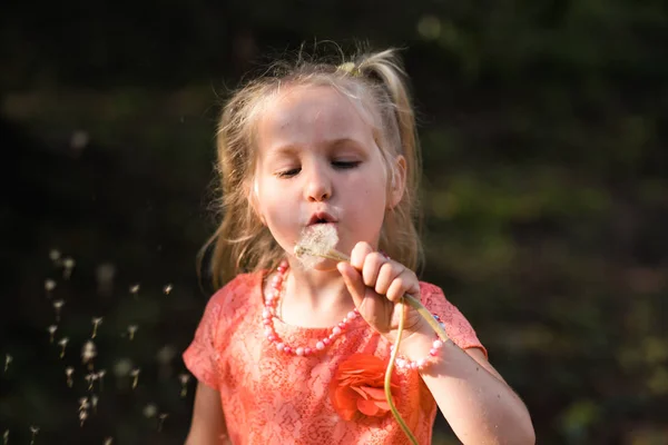 Blowing dandelions: Mãe feliz brincando com sua filha pequena menina e se divertindo - Jovem mãe branca branca vestindo verão vestido de cor vívida brilhante - conceito de família felicidade — Fotografia de Stock