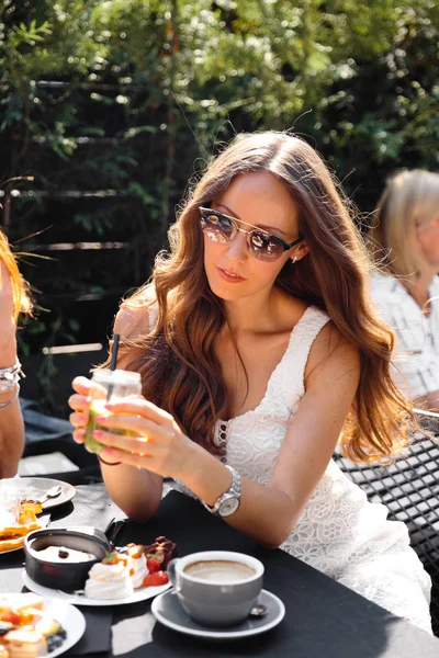 Grupo de amigos en blanco desayunando en el jardín a la mesa con comida y comunicándose, riendo concepto —  Fotos de Stock