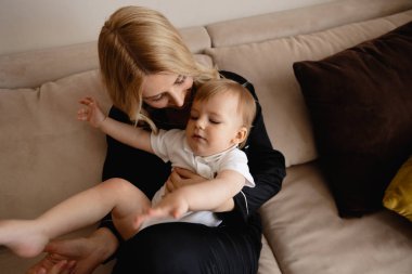 Genç sarışın anne aile evde düz onun bebek erkek oğlu ile kaliteli zaman sahip - siyah budoir elbise elbise uyku elbisesi giyiyor