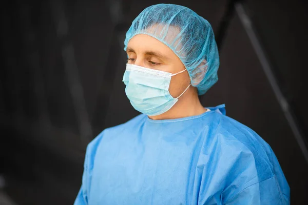 Сумний чоловік лікар або медсестра в медичній масці дивиться геть — стокове фото