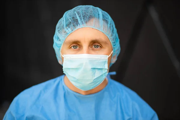 Mannelijke arts met medisch masker kijkt naar u — Stockfoto