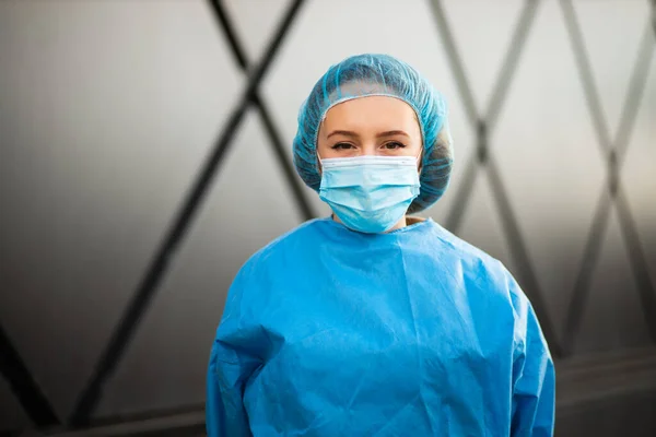 Retrato de doctora o enfermera en máscara médica y gorra quirúrgica mirándote — Foto de Stock