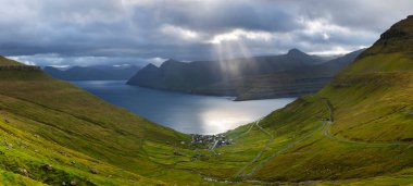Danimarka 'nın Faroe Adaları' ndaki Funningur köyünün çevresindeki dağ ve okyanus manzarası.