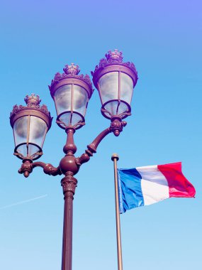 Paris ve Fransız bayrağının önünde mavi gökyüzü rüzgarda sallayarak tipik fener