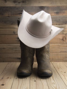 Cowboy boot and western hat on wooden background. clipart