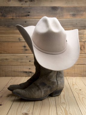 Cowboy boot and western hat on wooden background. clipart