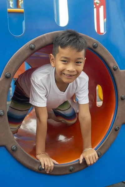 Portrait of cute Asia boy smiling happily playing on the color playground — Stock Photo, Image
