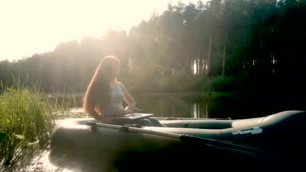 Una mujer trabaja en una computadora en un barco. Viaja por el agua. concepto de unidad con la naturaleza. Estilo de vida activo. Campaña. Aleación de agua. Internet. — Vídeo de stock