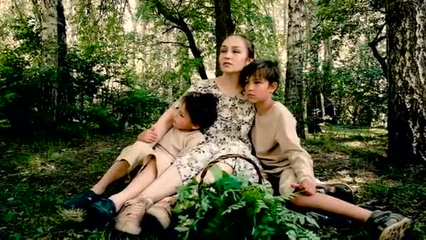 Dos hijos pequeños con mamá en un picnic. Caminar en el verano en el parque . — Vídeos de Stock