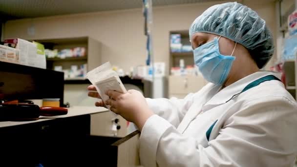 Farmacêutico em uma farmácia detém um pacote com pílulas. Doutor em uma clínica . — Vídeo de Stock