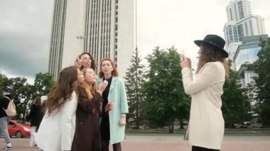 Kızlar baloncuk çıkarıyor. Şehirde çekilen bir fotoğraf. Tatil ve turizm konseptinin selfie 'si. Güzel kızlar. Temiz havada yürü. Beş kız 20-25 yaşlarında.