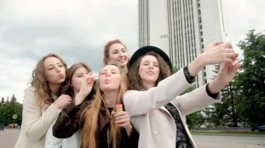 Kızlar baloncuk çıkarıyor. Şehirde çekilen bir fotoğraf. Tatil ve turizm konseptinin selfie 'si. Güzel kızlar. Temiz havada yürü. Beş kız 20-25 yaşlarında.