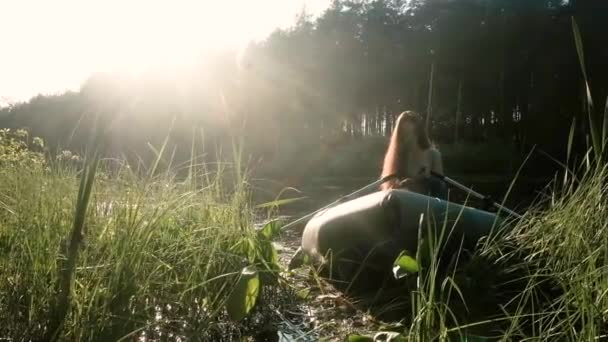 Flickan simmar i en båt vid solnedgången. Res med vatten. Begreppet enhet med naturen. Aktiv livsstil. Kampanj. Vattenlegering. soluppgång. flod, sjö, damm. — Stockvideo