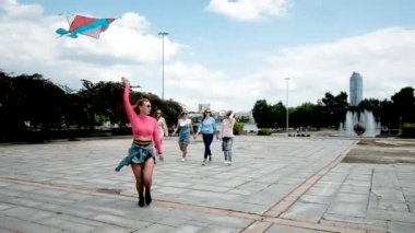 Genç güzel kadınlar renkli bir uçurtmayla koşar. 20-30 yaşlarında. Kız arkadaşlığı. Kız arkadaşlar şehirde kaygısız dolaşırlar. Hafta sonu Tatili Konsepti