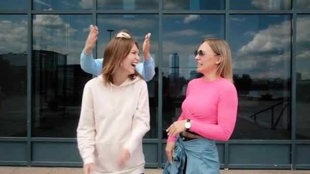 Beautiful young girls having fun, fooling around in the city. Girl friendship — Stock Video