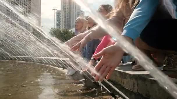 Meninas bonitas jovens se divertindo e brincando no gotejamento da fonte. Eles são felizes. As raparigas estão contentes por conhecer. 20-25 anos. Mulheres Amizade. Brincar com água — Vídeo de Stock