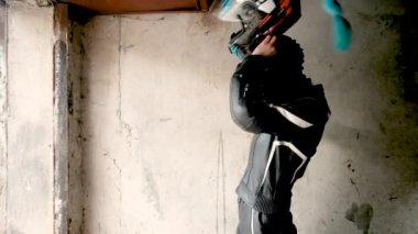 Güzel kadın motosikletçi garajda kask takıyor. Güvenlik kavramı, aktif bir yaşam tarzı, hız ve özgürlük. Moda motosiklet ekipmanları. 20-25 yaşlarında tatlı bir kız..