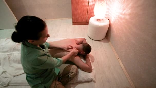 Vrouwelijke massage therapeut doet een rug massage van een man. Gezondheid en schoonheid concept. ontspanning en genot van massage. Medisch medisch kantoor. — Stockvideo