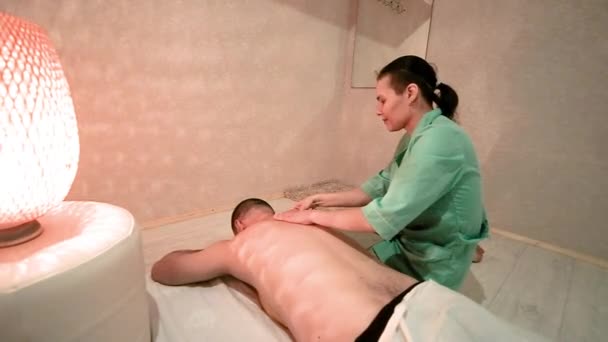 Vrouwelijke massage therapeut doet een rug massage van een man. Gezondheid en schoonheid concept. ontspanning en genot van massage. Medisch medisch kantoor. — Stockvideo