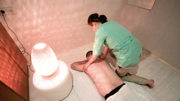 Masérka ženských masáží provádí masáž zad s mužem. Zdraví a krása. relaxace a potěšení z masáže. Lékařská ordinace. — Stock video