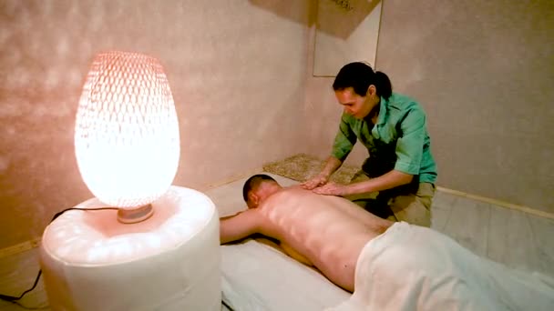 Masajista femenina haciendo un masaje de espalda de un hombre. Concepto de salud y belleza. relajación y placer del masaje. Consultorio médico. — Vídeos de Stock