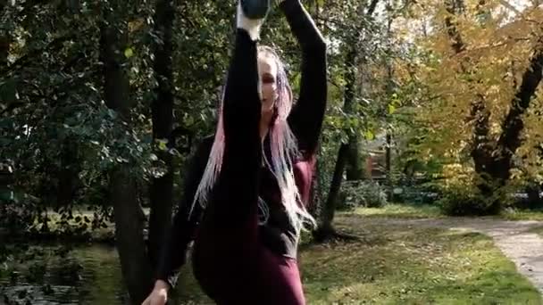 Mooi meisje is bezig met gymnastiek in het park. Fitness — Stockvideo