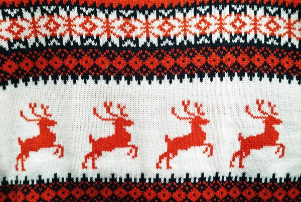 Texture and surface of knitted cloth with patterns of red deers on white background