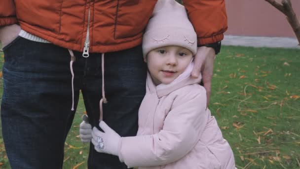 父亲和女儿在公园里散步 快乐的家庭宝宝抱着爸爸 父亲节 可爱的女孩用她的小手紧紧地抱着她的爸爸 温柔地 家人在一起散步 — 图库视频影像