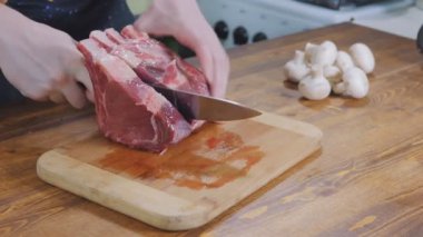 The chef cuts raw meat with the knife. Cooking. Preparing, Cut meat. Barbecue party.