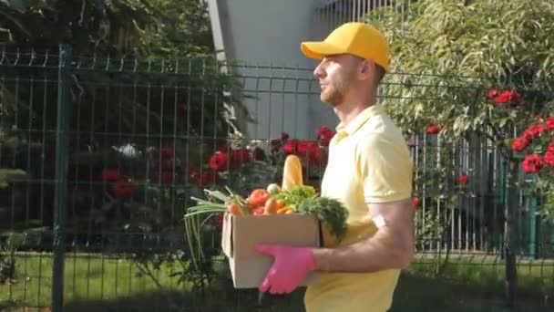 食品交付 网上购物 送货上门带着盒子的快递员社会距离 蔬菜类 — 图库视频影像
