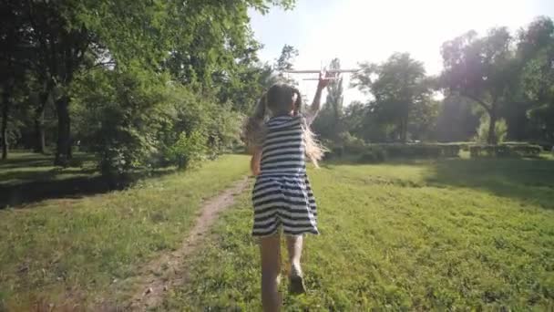Fille jouer avec un avion jouet. Bonne enfance. Jeu à l'air libre. Tourisme. Rêves de vol.