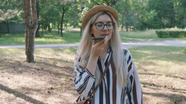 電話で音声メッセージを録音する 公園のスピーカーがスマホで話してる — ストック動画