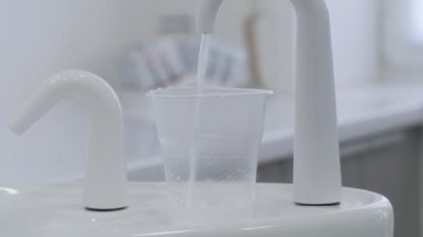 Diş aletleri. Ağzını çalkalamak için su. Diş hekimliğinde çalış.