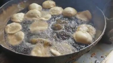 Kachoris pişiriyorum. Kachori baharatlı bir aperatiftir. Sokak yemeği. Hindistan. Yağda kızarma. Atıştırmalık.