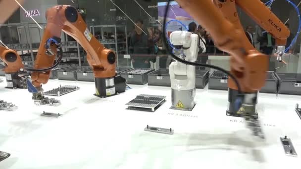 Soluciones de automatización del futuro con brazos robóticos en el stand de Kuka en la feria Messe en Hannover, Alemania — Vídeo de stock