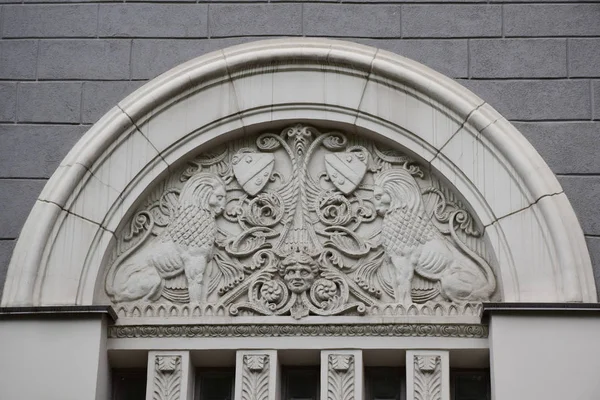 The relief above the entrance to the apartment building serves as one of the elements of the decor. The building was built in 1914, the architect Peter Antipov. Russia, Moscow, May 2018.