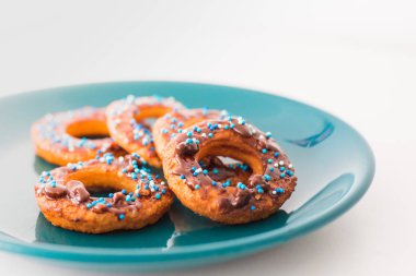 Çörek bir tabak ve ahşap bir masa.
