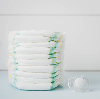 Çocuk bezi bir beyaz gardrop karşı yığını. kare