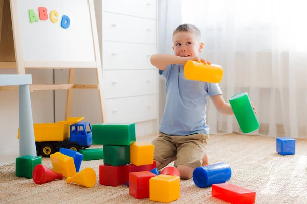 Crianças pré-escolares felizes brincam com blocos de brinquedo. — Fotografia de Stock