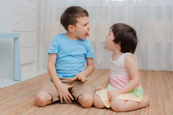 Broer en zus grimassen debat. Een confrontatie tussen broers en zussen. Kinderen zijn pestkoppen. — Stockfoto