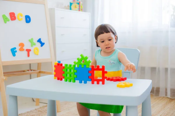 Yaşında Bir Çocuk Renkli Oyuncak Blokları Olan Bir Masada Oynuyor — Stok fotoğraf
