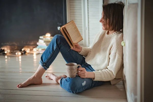 Piękna młoda kobieta czytanie książki w domu — Zdjęcie stockowe
